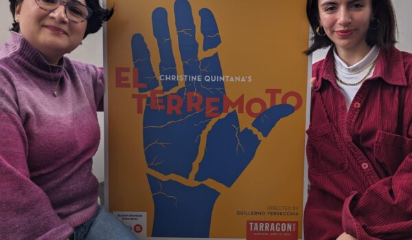 2 mujeres sujetando un cartel de la obra El Terremoto